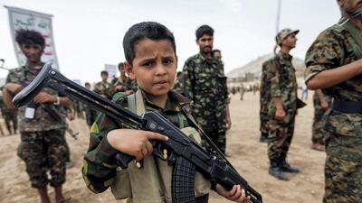 A Yemeni boy poses with a Kalashnikov assault rifle during a gathering of newly-recruited Houthi fighters in Sanaa on July 16, 2017. Mohammed Huwais / AFP