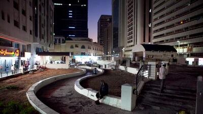 People sit in the former garden off Hamdan Street, which was to be a dining and entertainment area.