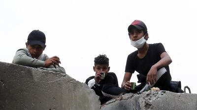 Iraqi protesters take cover during clashes with anti-riot police forces at the Al Rasheed street in central Baghdad. EPA