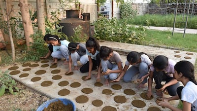 In this picture taken on October 18, 2019 girls at Gotirth Vidyapeeth, a school for Hindu and Vedic teachings, make cow dung patties in preparation to making them into small oil lamps to be used in the upcoming Hindu festival of Diwali, or Festival of Lights, in Ahmedabad. AFP
