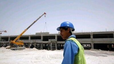 A worker walks past the foundation for a mall parking structure on Abu Dhabi's Yas Island on April 20, 2009. Nicole Hill / The National