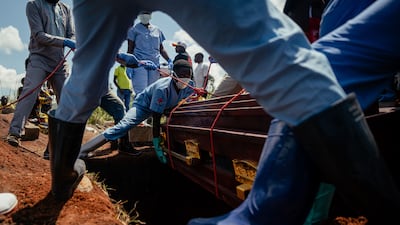 Congolese Red Cross workers lower the coffin of a woman suspected of having died from Ebola at a cemetery in Bunia. AFP
