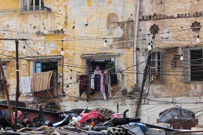 A woman look on from the window of a delapidated building in the Bab Al Tabbaneh neighborhood of the northern Lebanese city of Tripoli. AFP