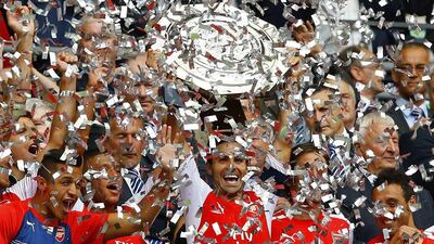 Arsenal’s Mikel Arteta, centre, lifts the Community Shield after a 3-0 victory over Manchester City during their English Community Shield soccer match at Wembley Stadium in London, August 10, 2014. REUTERS/Darren Staples