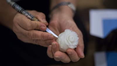A Thai woman carves a vegetable into the form of a rose during a fruit and vegetable carving competition in Bangkok. It is a royal tradition that has proved bountiful through the ages and one that Thailand's fruit carvers are determined to keep alive - even as young people peel away from the unique art form. Roberto Schmidt / AFP