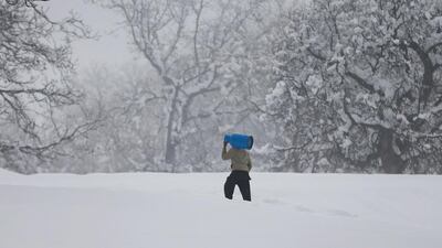An Afghan man caries gas cylinder on his shoulder on the snowy day on the outskirts of Kabul, Afghanistan January 24, 2017. Omar Sobhani/Reuters