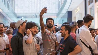 Apple customers queue through the night at The Dubai Mall to be one of the first to get the new Apple devices. Leslie Pableo / The National