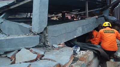 Indonesian rescuers look for survivors in a collapsed building in Mamuju after a 6.2-magnitude earthquake rocked Sulawesi island. National Search and Rescue Agency / AFP