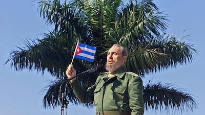 Cuban President Fidel Castro waves a flag during during a visit on January 27, 2001, to the Havana neighborhood of San Jose de las Lajas. Adalberto Roque / AFP