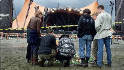 Young people lay down flowers on the grounds of the Roskilde music festival on July 1, 2000, following a fatal incident. The festival in western Denmark was hit by the first tragedy in its 30-year history when eight people were crushed and trampled to death in a crowd surge as American group Pearl Jam were playing on the main stage. AFP