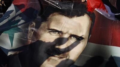 Shadows of Syrians are reflected on a giant poster showing Bashar Al Assad, during a supporting rally in Damascus (AP Photo/Muzaffar Salman)