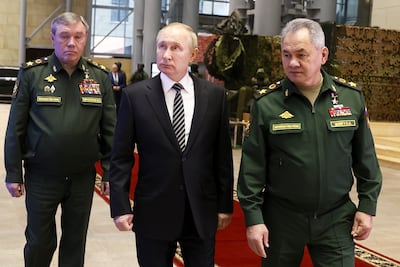 Russian President Vladimir Putin, escorted by Russian Defense Minister Sergei Shoigu, right, and General Staff Valery Gerasimov walk after attending a meeting of the Russian Defense Ministry Board in Moscow, on December 21, 2021. Kremlin Pool photo via AP