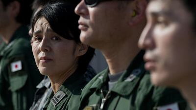 A Japan’s Maritime Self-Defense Force Personnel looks on as she stands to wave to her colleagues on a PC3 aircraft before taking off for Australia to join the search operation for the missing Malaysia Airlines flight MH370. Mohd Rasfan / AFP