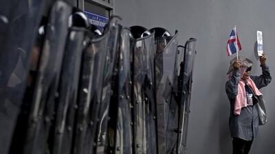 A Thai anti-government protester stands next to soldiers during a protest in Bangkok on February 17, 2014, against the government’s repeatedly delayed payments for rice. Pornchai Kittiwongsakul / AFP photo