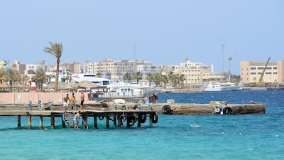 Tourists walk on the beach in the Egyptian Red Sea resort town of Hurghada, on April 3, 2019.