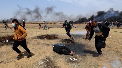 A wounded Palestinian falls on the ground during clashes with Israeli troops at a protest where Palestinians demand the right to return to their homeland, at the Israel-Gaza border in the southern Gaza Strip, April 27, 2018. REUTERS/Ibraheem Abu Mustafa TPX IMAGES OF THE DAY
