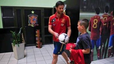 Xabi Alonso signs an autograph for a young fan before a news conference where the Spain midfielder was adamant his side would stick to their passing principles. Alvaro Barrientos / AP Photo