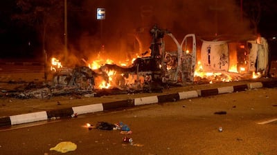 Police vehicles go up in flames after a riot broke out in Singapore's Little India, AP Photo
