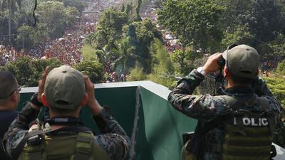 Philippine National Police Special Action Force use binoculars to scan the route as Filipino Roman Catholic devotees join a procession to celebrate the feast day of the Black Nazarene Monday in Manila. The raucous celebration drew tens of thousands of devotees in a barefoot procession that lasted for several hours around the Manila streets and ended up with several people injured. Bullit Marquez / AP Photo