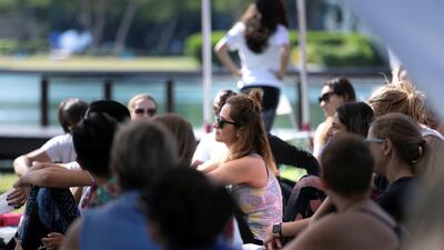 People attend the class under a tent.