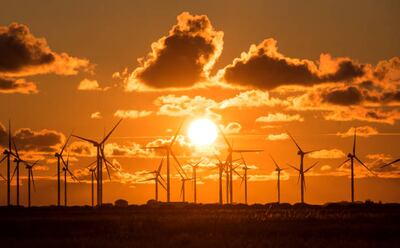 The sun sets behind a wind farm in Germany. Countries are under pressure to switch to renewable energies. Getty