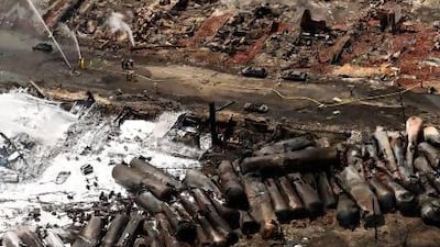 Fire fighters continue to water smouldering rubble in Lac Megantic, where a runaway train derailed igniting tanker cars carrying crude oil.
