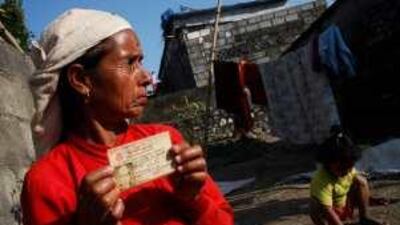 Jamuna Baral, 45, holds the citizenship card of her missing husband, Chaman Lal Baral, in Pokhara, Nepal.