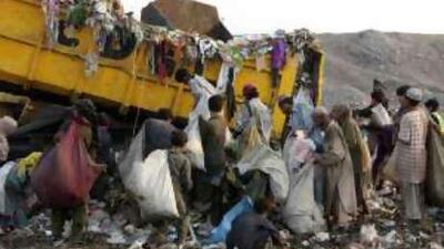 Pakistani scavengers collect recyclable material from garbage to sell and earn their living in Lahore.