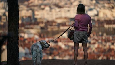 A woman and her dog stand on a hill above Lyon, central France, on March 20, 2020. AP Photo