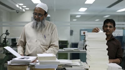 Employees of the Riyadh-based King Faisal Centre for Research and Islamic Studies in the think tank's book binding room. Justin Vela/The National