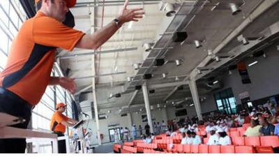 Mark Grennell, a bid catcher at an auction hosted in Dubai to sell off industrial construction equipment, interprets the gestures of audience members and relays bids to the auctioneer.