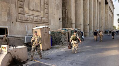 US Army soldiers (L), stand next to the former Ba'ath Party Headquarters near entrance to the International Zone on May 30, 2021 in Baghdad, Iraq. AFP