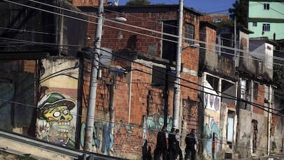 Police officers from the Pacifying Police Unit (UPP) patrol the streets at the Complexo do Alemao slum in Rio de Janeiro. (Pilar Olivares / Reuters / March 30, 2014)