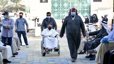 People wearing protective masks arrive to cast their votes at a polling station in Kuwait City. EPA