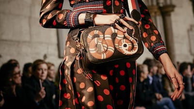 A polka-dot top and skirt is teamed with a snake motif bag. Courtesy Gucci