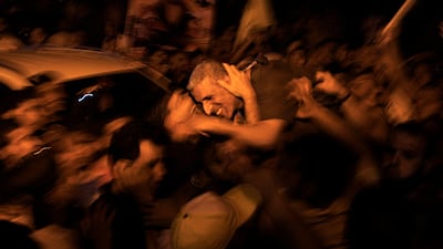 Freed Palestinian prisoner Ateya Abu Moussa, who was held by Israel for 20 years, hugs his relatives. AFP PHOTO / SAID KHATIB