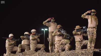 Members of Saudi security forces salute. SPA via Reuters