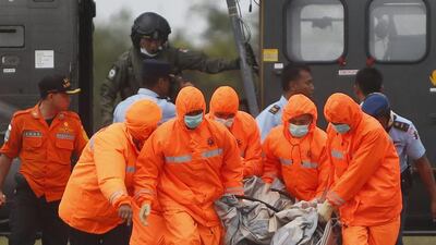 Indonesian rescuers carry a part of crashed AirAsia plane from a Singapore's Navy helicopter during a search and rescue operation at the Iskandar Military Airport in Pangkalan Bun, Central Borneo, Indonesia on January 4. Adi Weda ?EPA