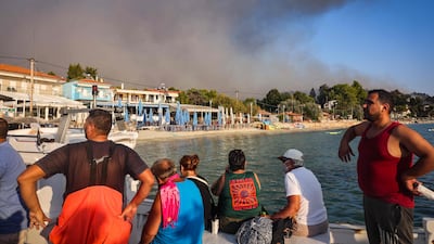 Nearly 500 tourists were evacuated in small boats as a wildfire approached the village of Siviri in northern Greece. AFP