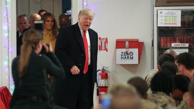 US President Donald Trump and first lady Melania Trump arrive to greet military personnel at the dining facility during an unannounced visit to Al Asad Air Base, Iraq. Reuters