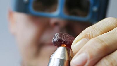 Ian Harebottle, chief executive of British precious stones miner Gemsfield, inspects a rare 40.23-carat rough ruby unearthed at its Montepuez deposit in Mozambique, during a rough ruby auction in Singapore on December 4, 2014. Edgar Su / Reuters