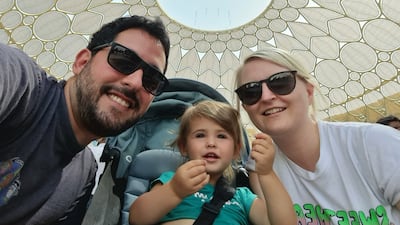 Katy Gillett, right, with her husband and daughter, aged 20 months, under Al Wasl Plaza's dome. Katy Gillett / The National