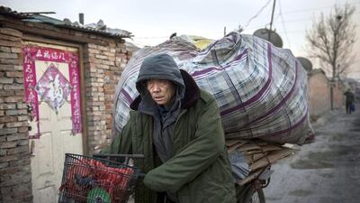 A Chinese labourer wheels goods collected to be recycled in the Dong Xiao Kou village. Kevin Frayer / Getty Images