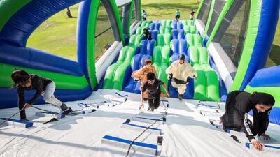 Participants climb up the "Speed Bumps" obstacle. Leslie Pableo for The National