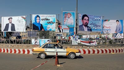 A vehicle drives in front of posters of parliamentarian candidates during the first day of a new election campaign in Kabul, Afghanistan. Reuters