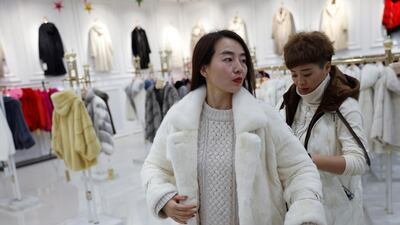 A customer tries on a mink fur coat at a shopping mall in Shangcun, Hebei Province, China. Reuters
