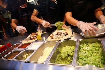 Employees serve customers at a Chipotle fast-food restaurant in San Pedro Garza Garcia, Mexico. Reuters