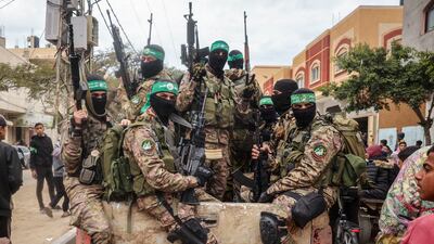 Hamas fighters patrol a street before they handover three Israeli hostages to a Red Cross team in Deir el-Balah, central Gaza, on February 8, 2025. Hamas militants handed over three Israeli hostages on February 8, as part of the fifth exchange under a fragile Gaza ceasefire, with 183 prisoners held by Israel due to be released later in the day. (Photo by Eyad BABA / AFP)