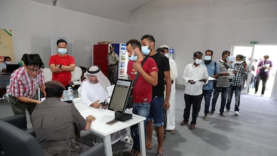 Officials help people who have overstayed their visa get their paperwork in order at the General Directorate of Residency and Foreigners Affairs Dubai in Al Awir. Pawan Singh / The National