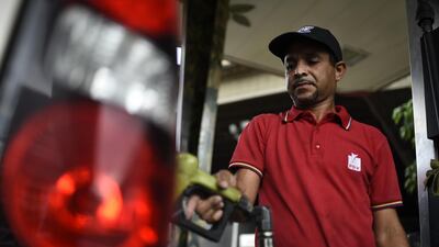 An employee refuels a vehicle at a Petroleos de Venezuela SA (PDVSA) gas station in Caracas, Venezuela. President Donald Trump sanctioned Venezuela's state-owned oil company PDVSA and its central bank. Bloomberg